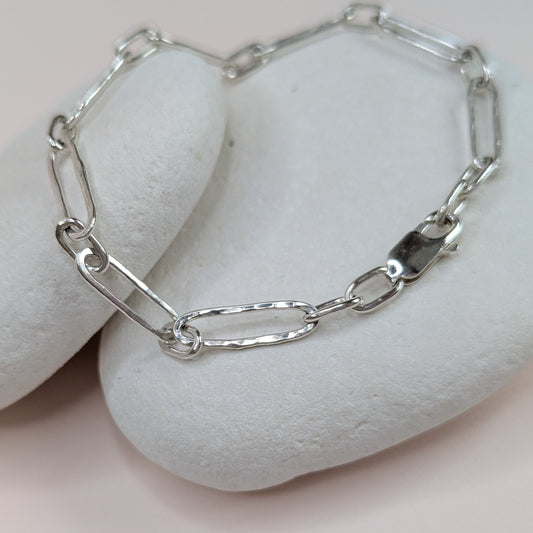 Silver chain bracelet on a white stone surface