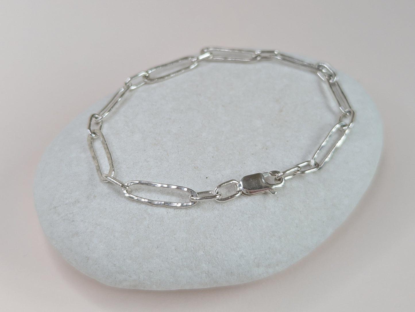 Silver chain bracelet on a light gray stone