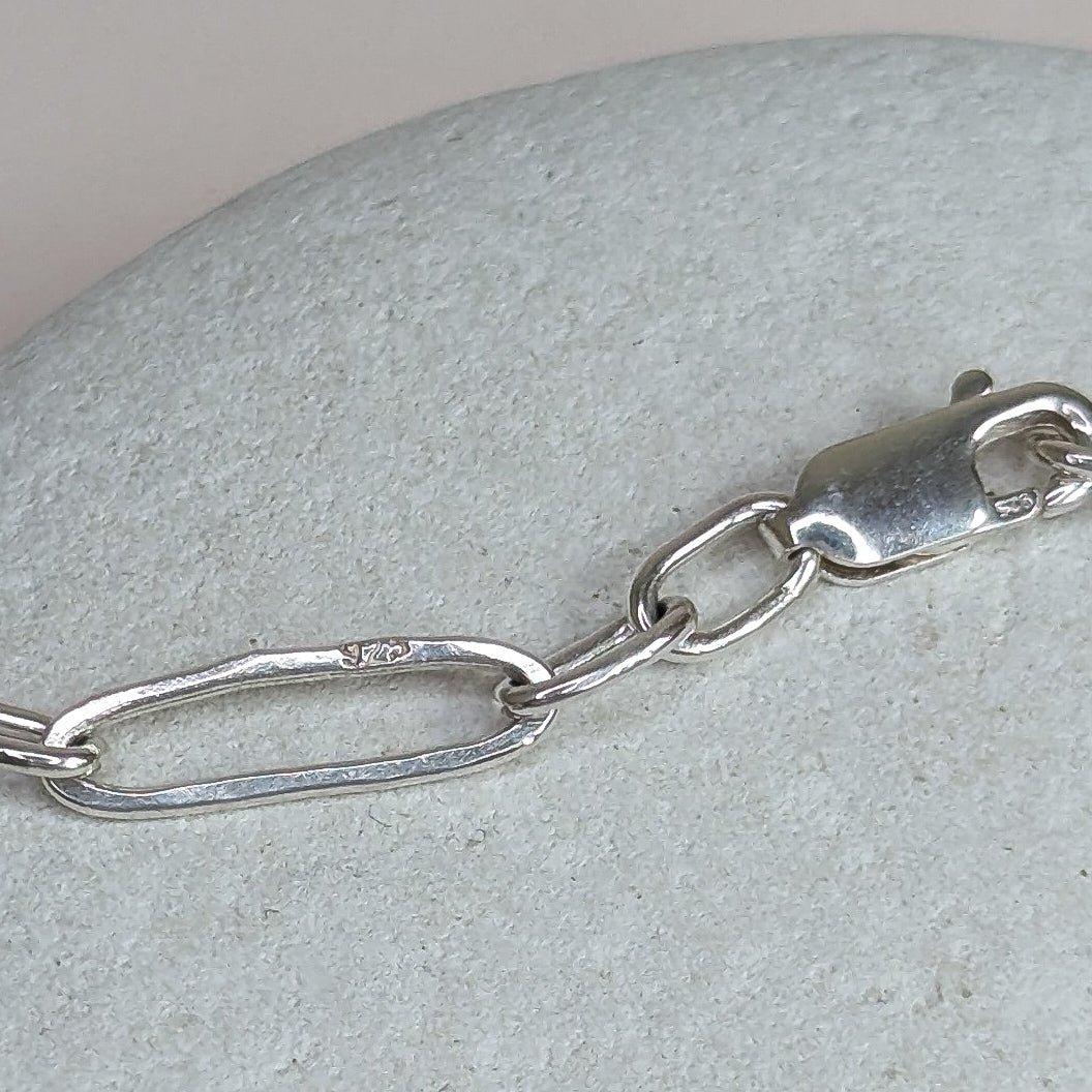 Silver chain bracelet on a textured stone surface