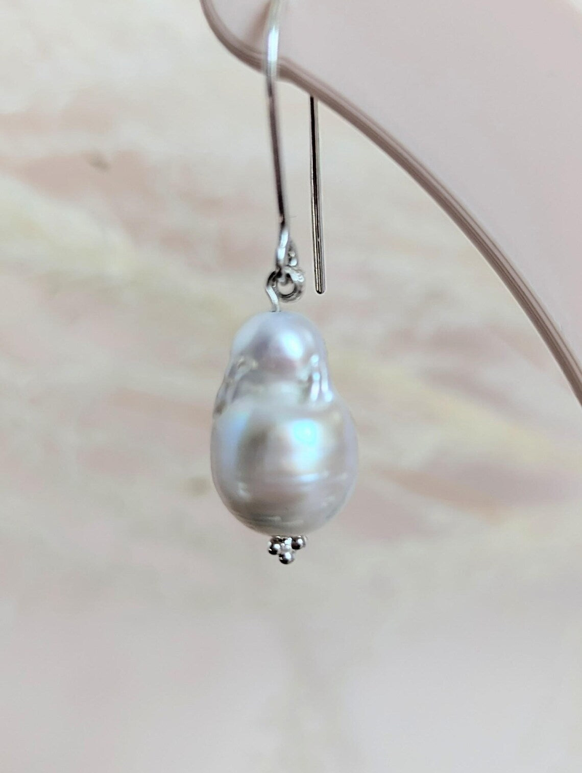 Handcrafted 925 sterling silver genuine large Baroque pearl drop earrings worn on a modern arched sterling silver ear wire
