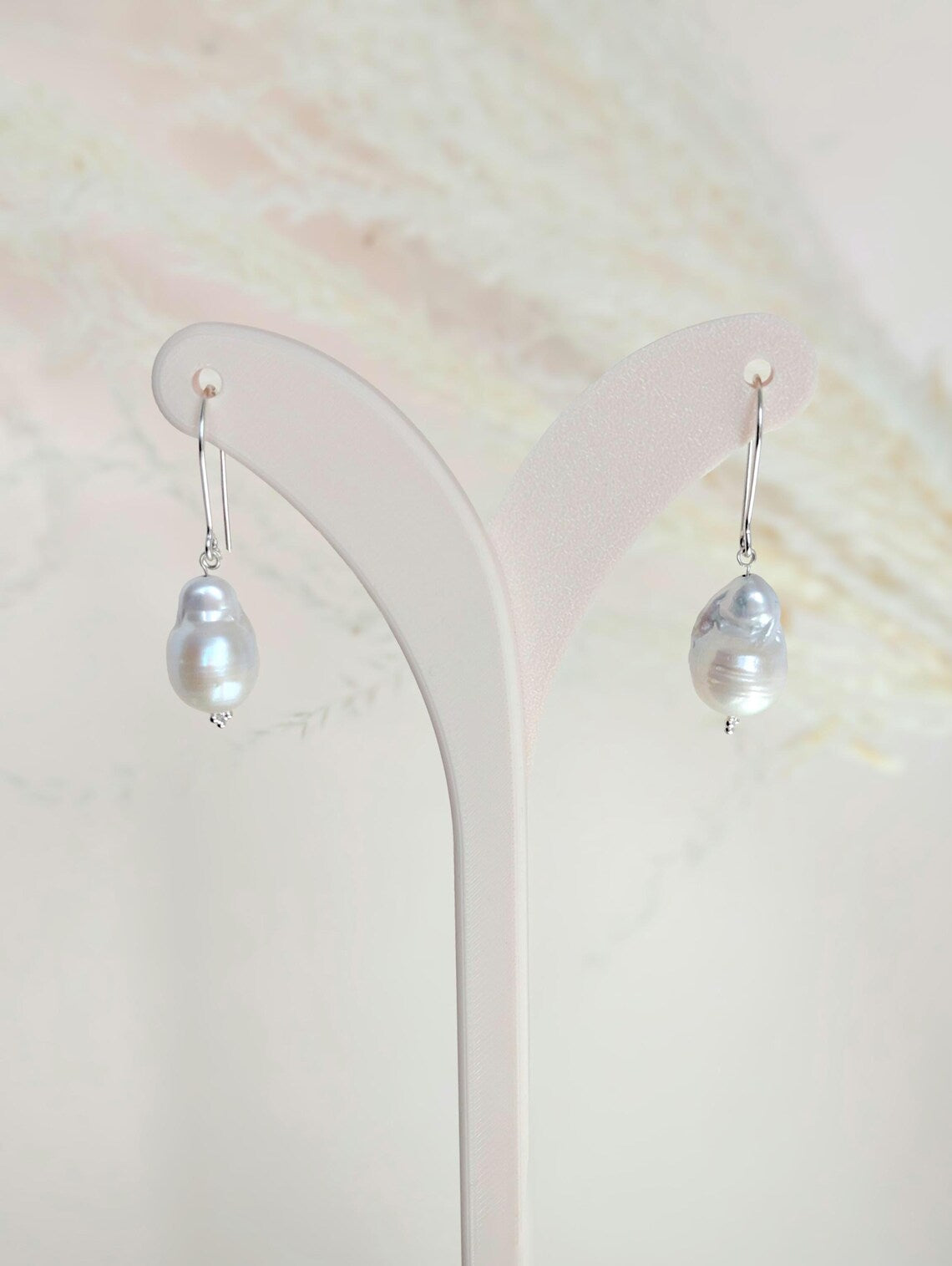 Handcrafted 925 sterling silver genuine large Baroque pearl drop earrings worn on a modern arched sterling silver ear wire