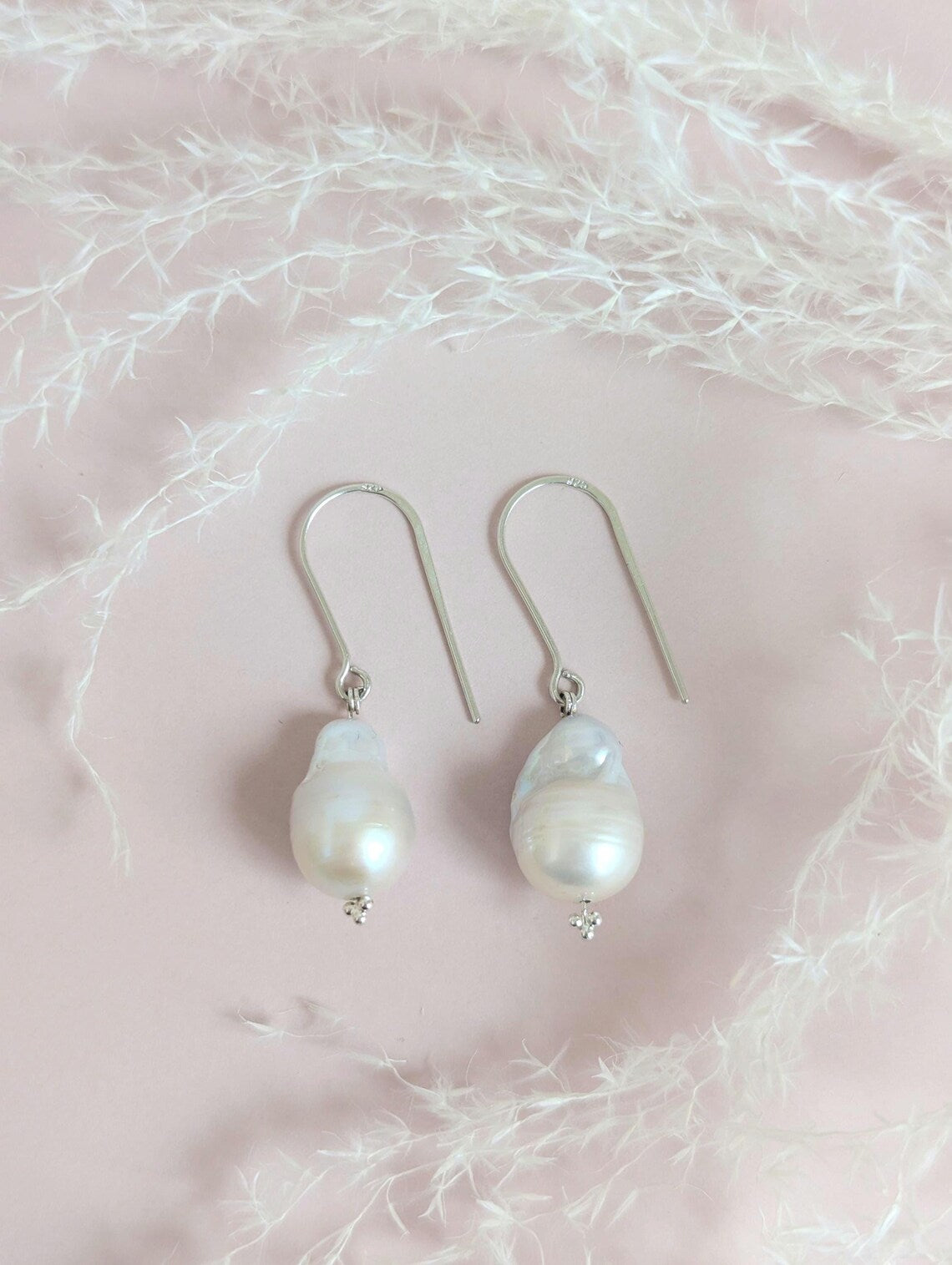 Handcrafted 925 sterling silver genuine large Baroque pearl drop earrings worn on a modern arched sterling silver ear wire