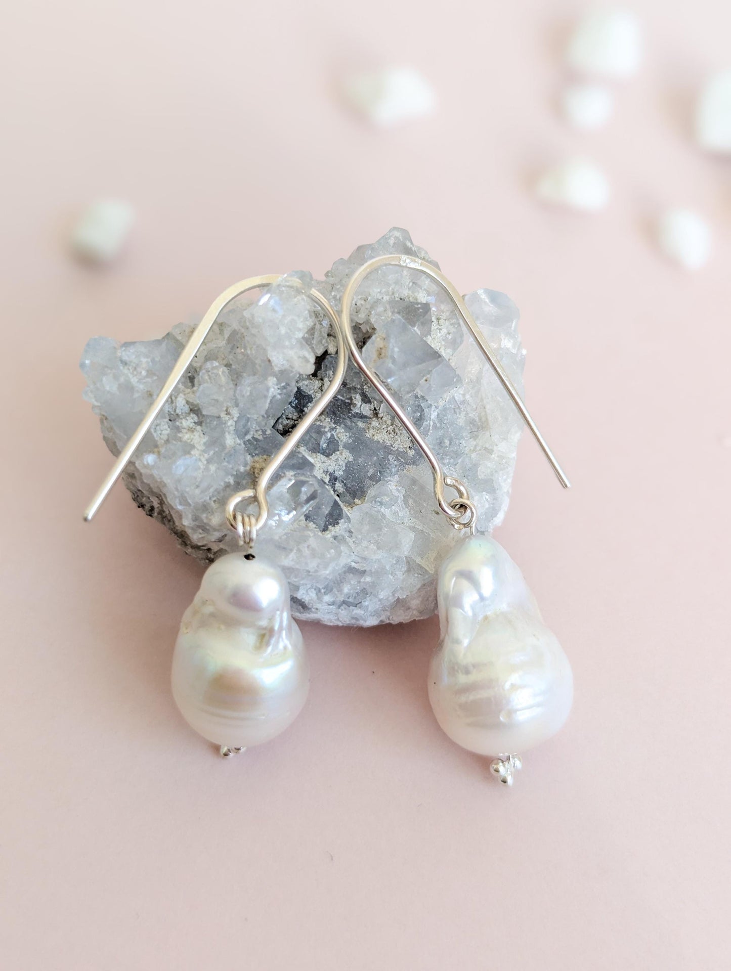 Handcrafted 925 sterling silver genuine large Baroque pearl drop earrings worn on a modern arched sterling silver ear wire