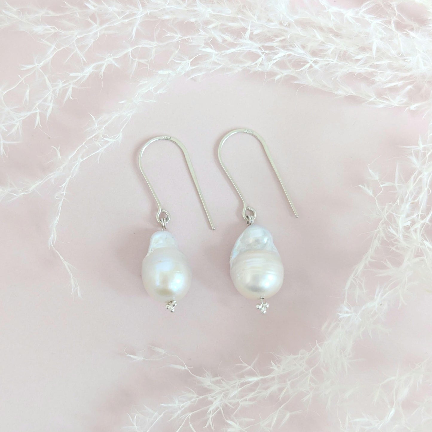 Handcrafted 925 sterling silver genuine large Baroque pearl drop earrings worn on a modern arched sterling silver ear wire