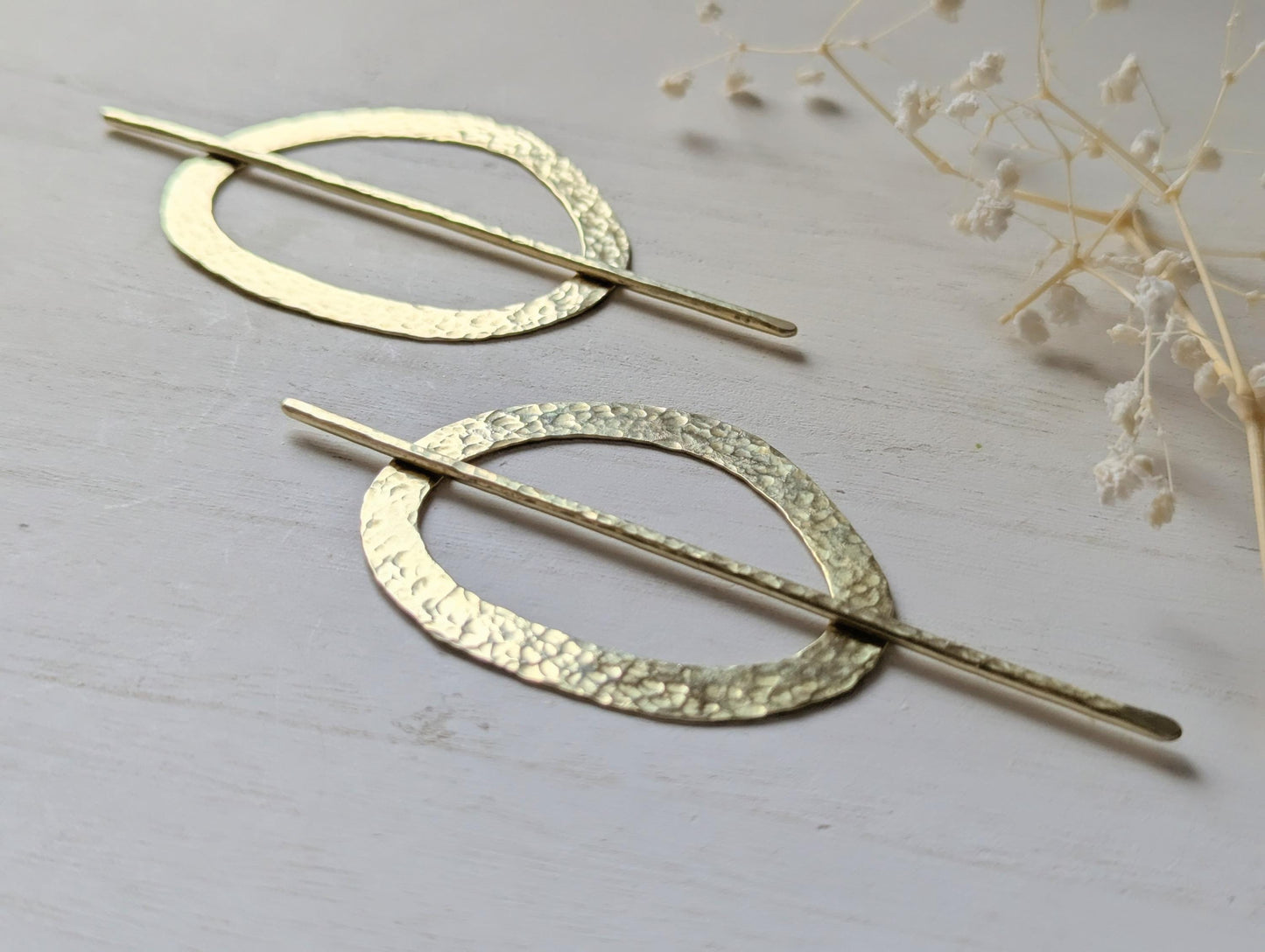 Pebble gold hammered brass round hair stick barrette bun holder - close up of the hammered texture on the pin and pebble shaped barrette