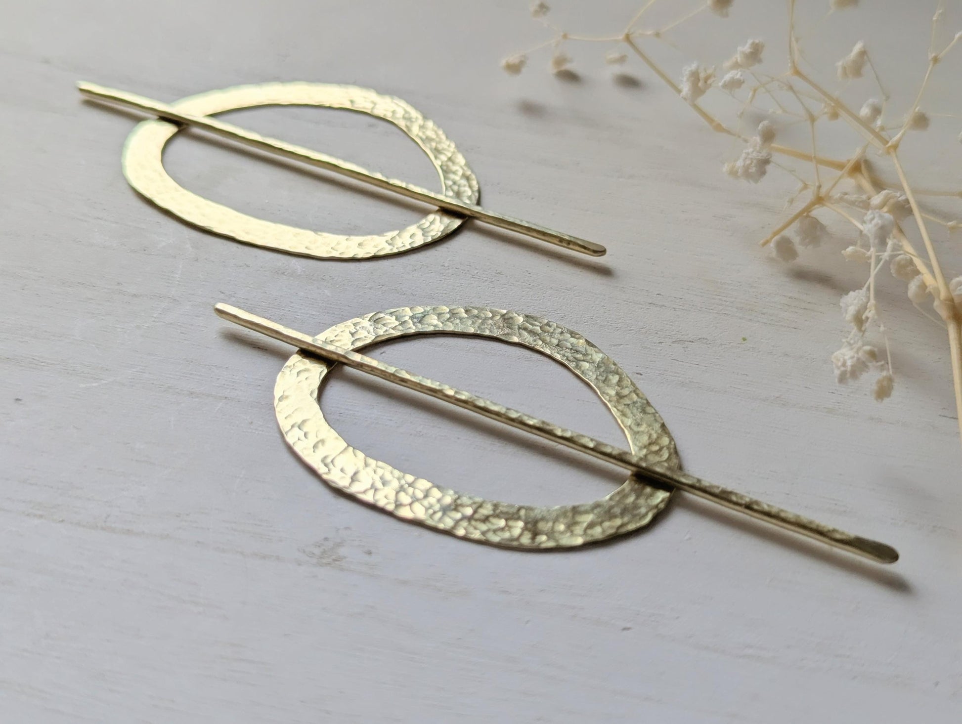 Pebble gold hammered brass round hair stick barrette bun holder - close up of the hammered texture on the pin and pebble shaped barrette