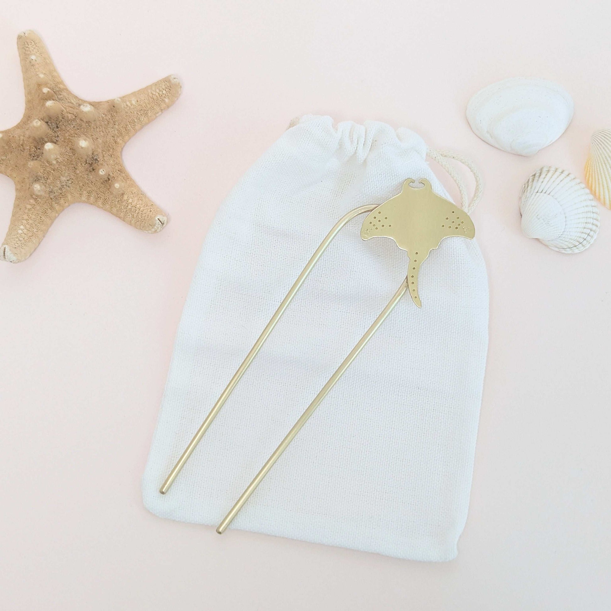 Manta Ray U Pin French hair fork in a brushed brass satin finish - Manta ray secured on the top right of the hair fork with dot and star details on the pectoral finsh laid flat