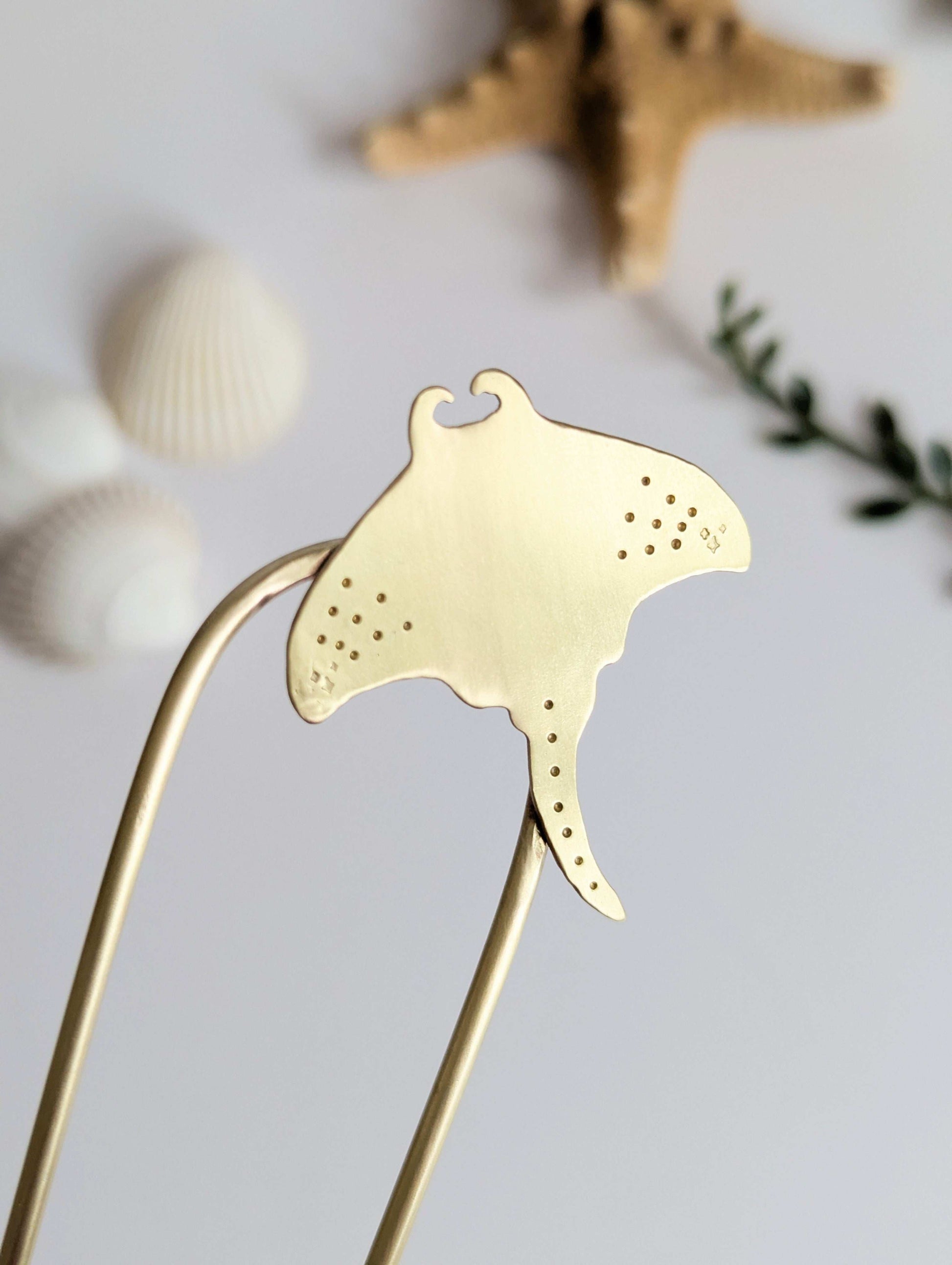 Manta Ray U Pin French hair fork in a brushed brass satin finish - close up of Manta ray secured on the top right of the hair fork with dot and star details on the pectoral fins