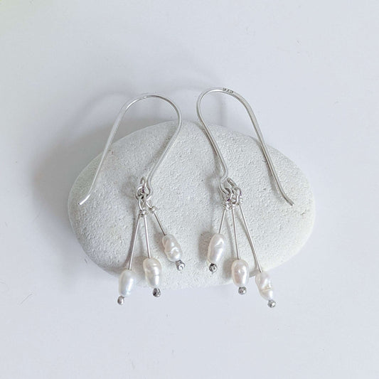 Dainty freshwater seed pearl dangle cascade drop earrings in Sterling silver - laid flat