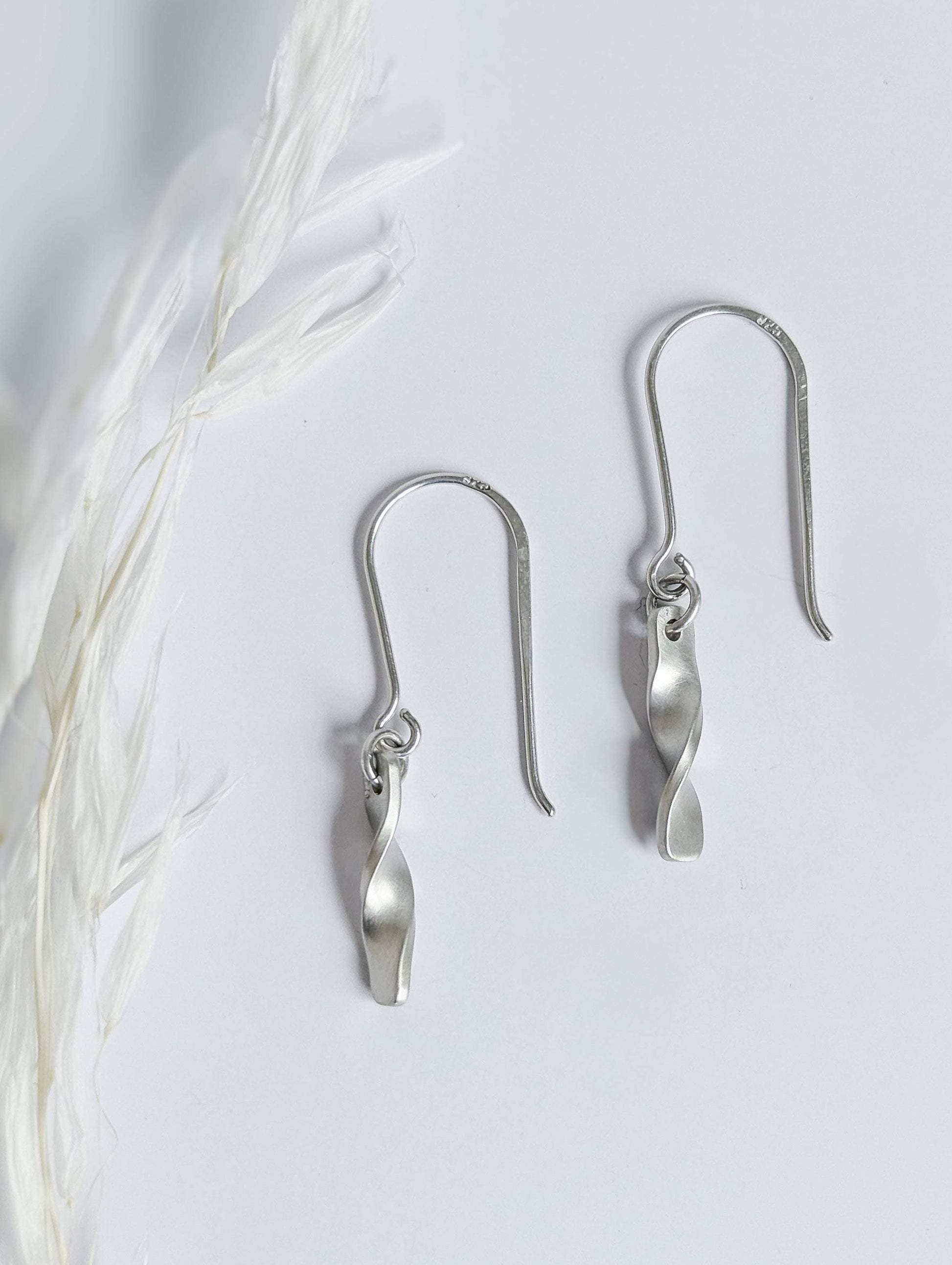 Minimalist satin brushed sterling silver twist drop earrings - top down view