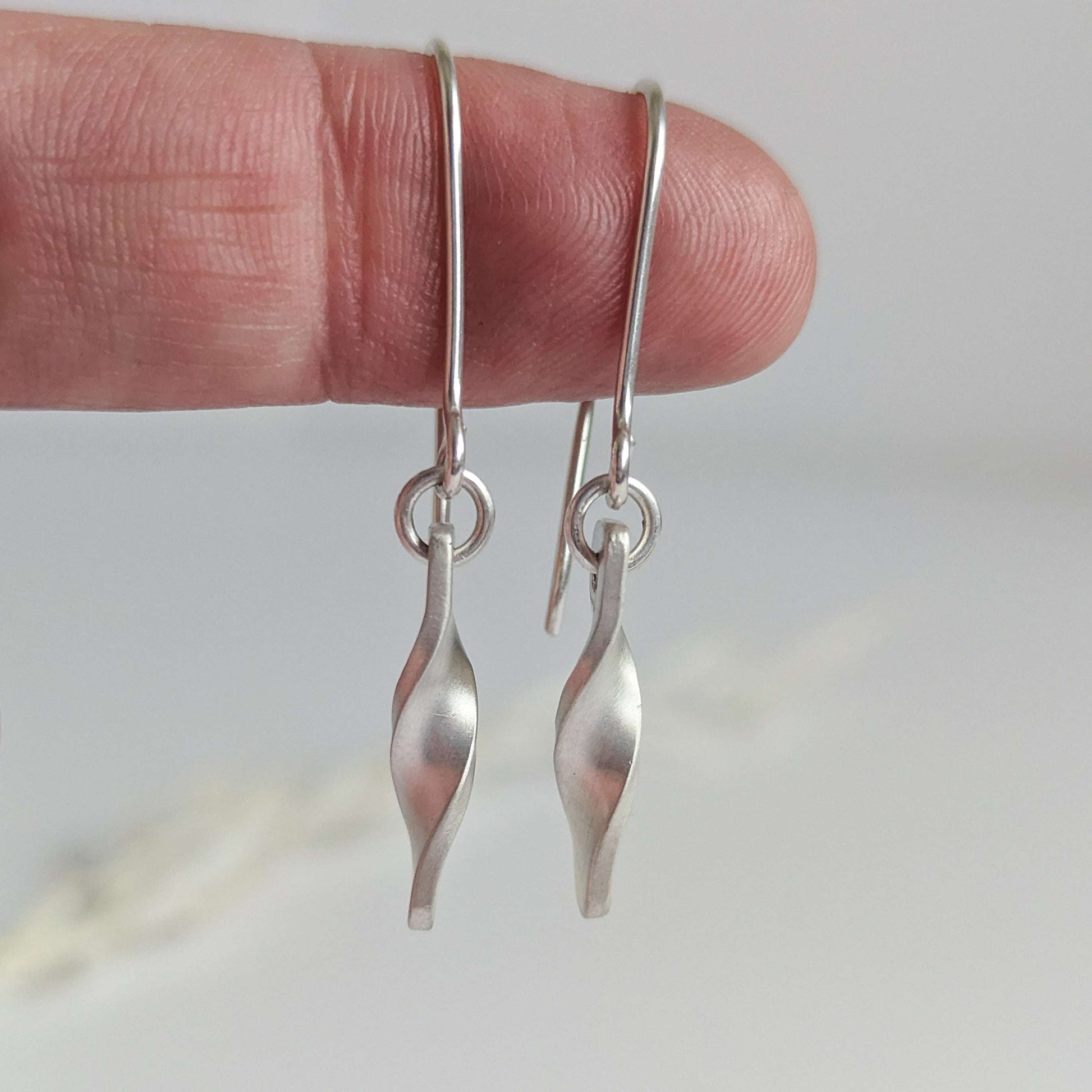 Minimalist satin brushed sterling silver twist drop earrings - close up