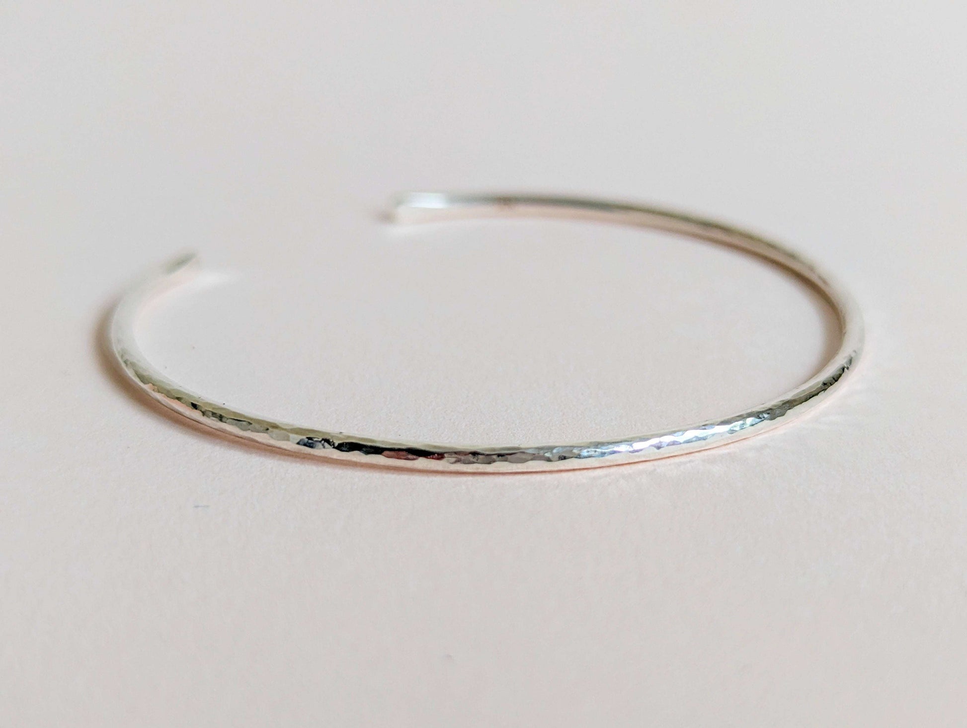 Silver bangle on a light gray background