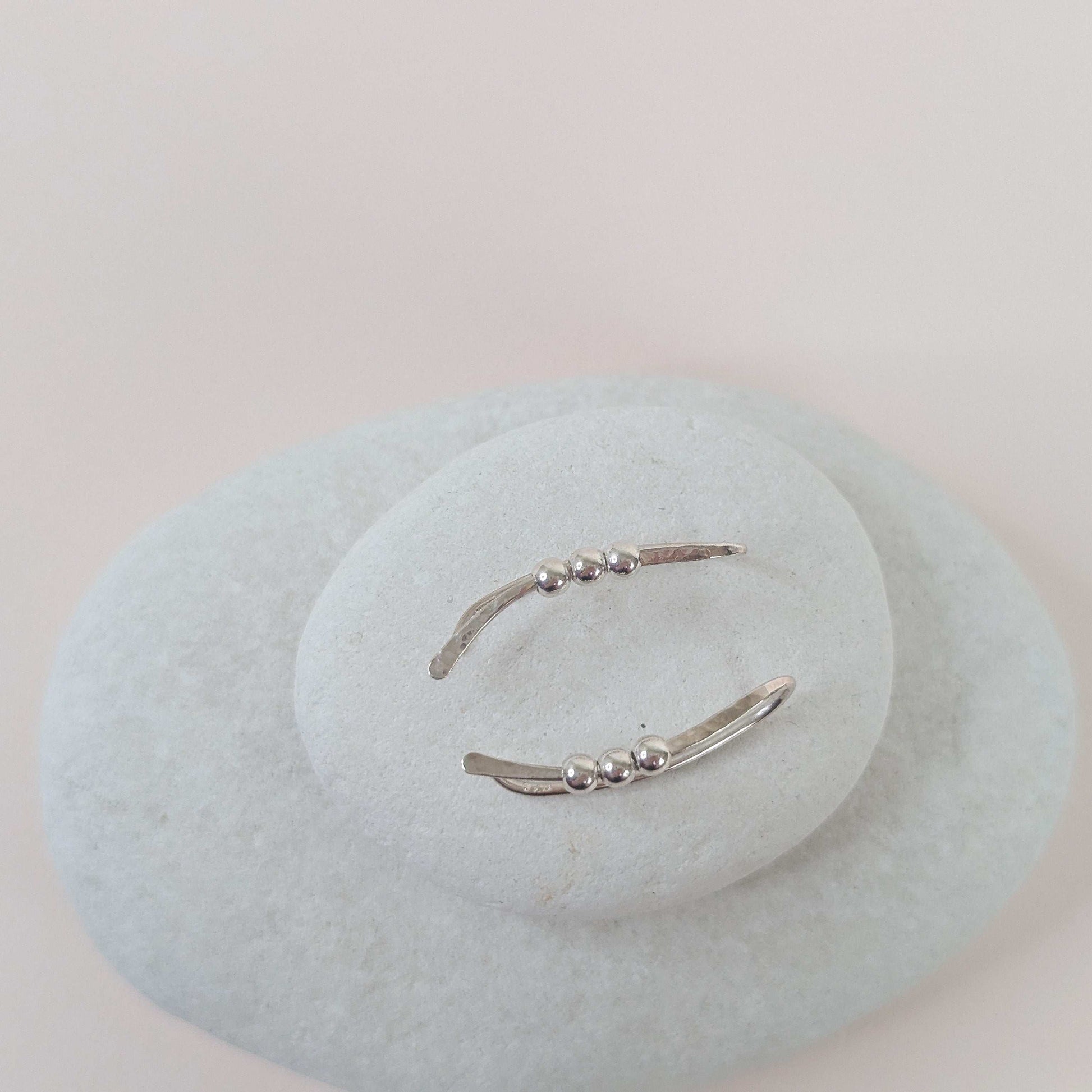 Silver  bead ear climber earrings with small beads on a light white stone