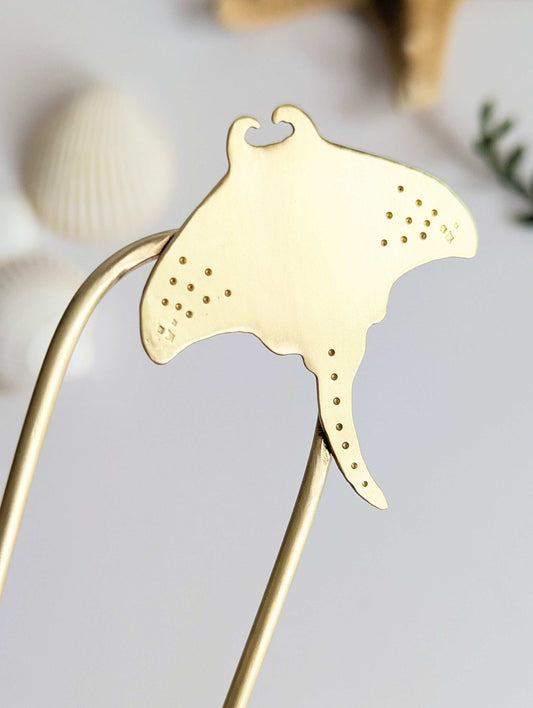 Manta Ray U Pin French hair fork in a brushed brass satin finish - close up of Manta ray secured on the top right of the hair fork with dot and star details on the pectoral fins