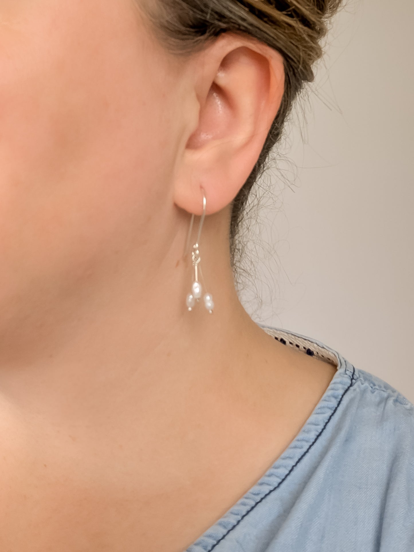 Dainty freshwater seed pearl dangle cascade drop earrings in Sterling silver - worn on earlobe