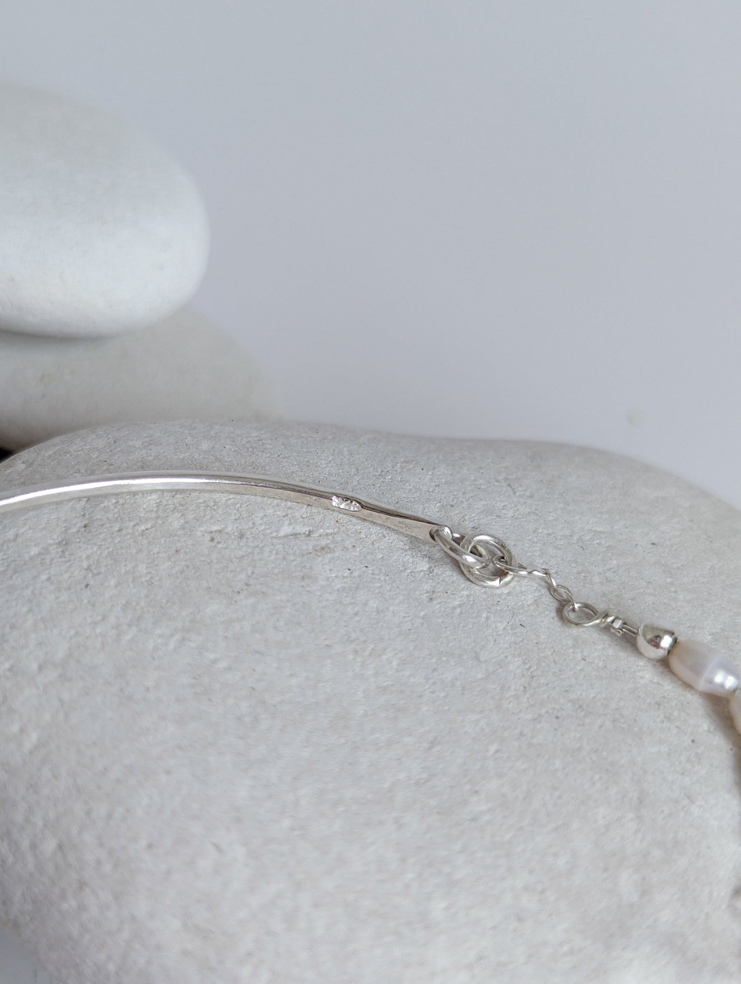 Thin sterling silver dainty cuff bangle with seed pearl bar chain - shows 925 sterling silver stamp on the inside end of cuff