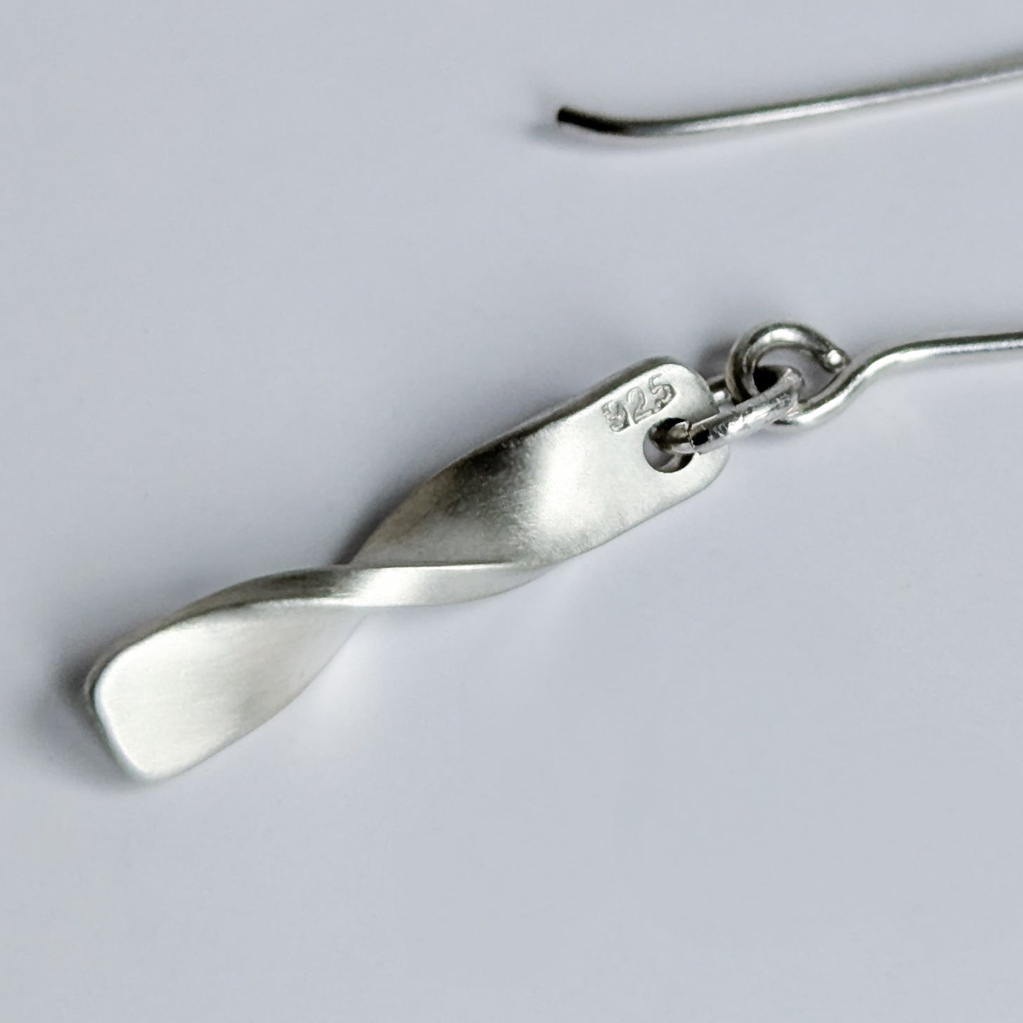 Minimalist satin brushed sterling silver twist drop earrings - close up on 925 stamp