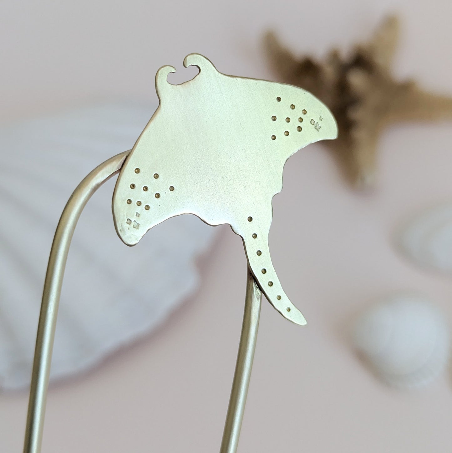 Manta Ray U Pin French hair fork in a brushed brass satin finish - close up of Manta ray secured on the top right of the hair fork with dot and star details on the pectoral fins