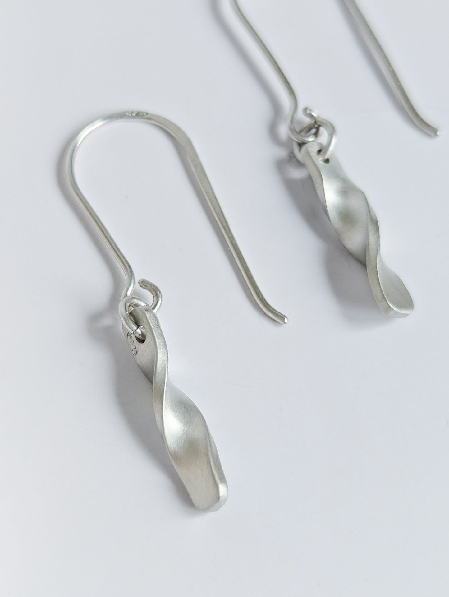 Minimalist satin brushed sterling silver twist drop earrings - close up