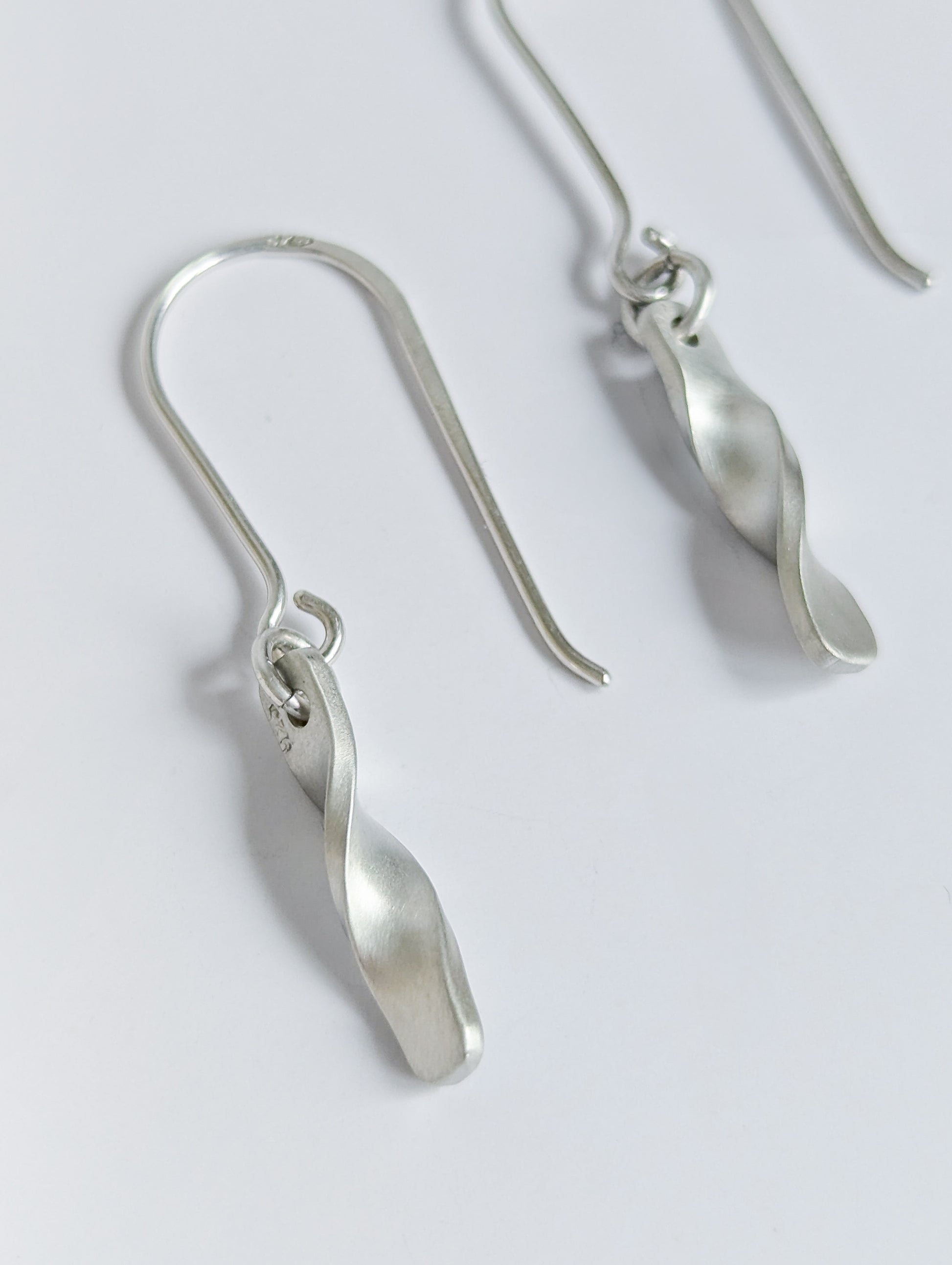 Minimalist satin brushed sterling silver twist drop earrings - close up