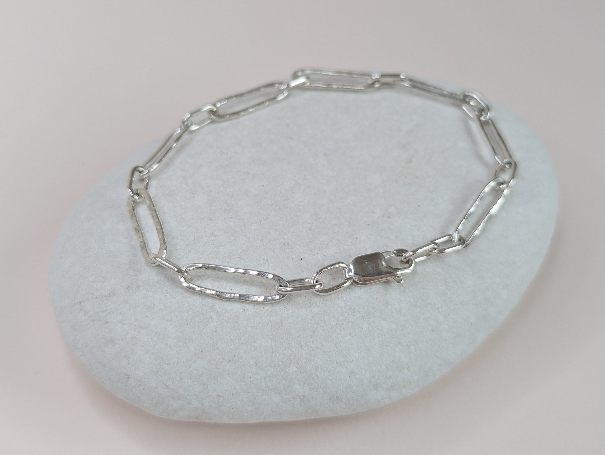 Silver chain bracelet on a light gray stone