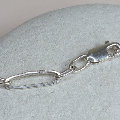 Silver chain bracelet on a textured stone surface