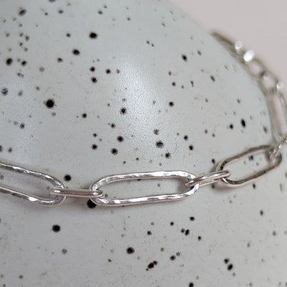 Silver chain necklace on a speckled surface
