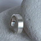 Silver ear cuff on a textured stone surface