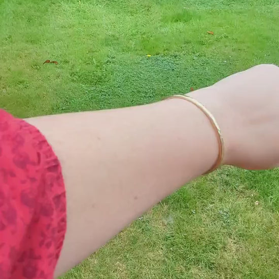 open cuff hammered texture sold brass bangle, is a beautiful sunshine gold colour - shown being worn