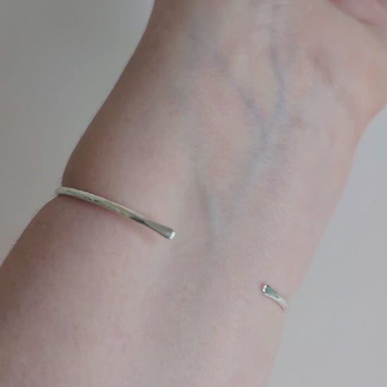 slim hammered textured silver cuff bangle being worn on wrist