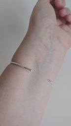 slim hammered textured silver cuff bangle being worn on wrist