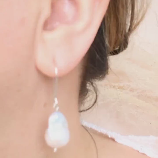 video Handcrafted 925 sterling silver genuine large Baroque pearl drop earrings worn on a modern arched sterling silver ear wire