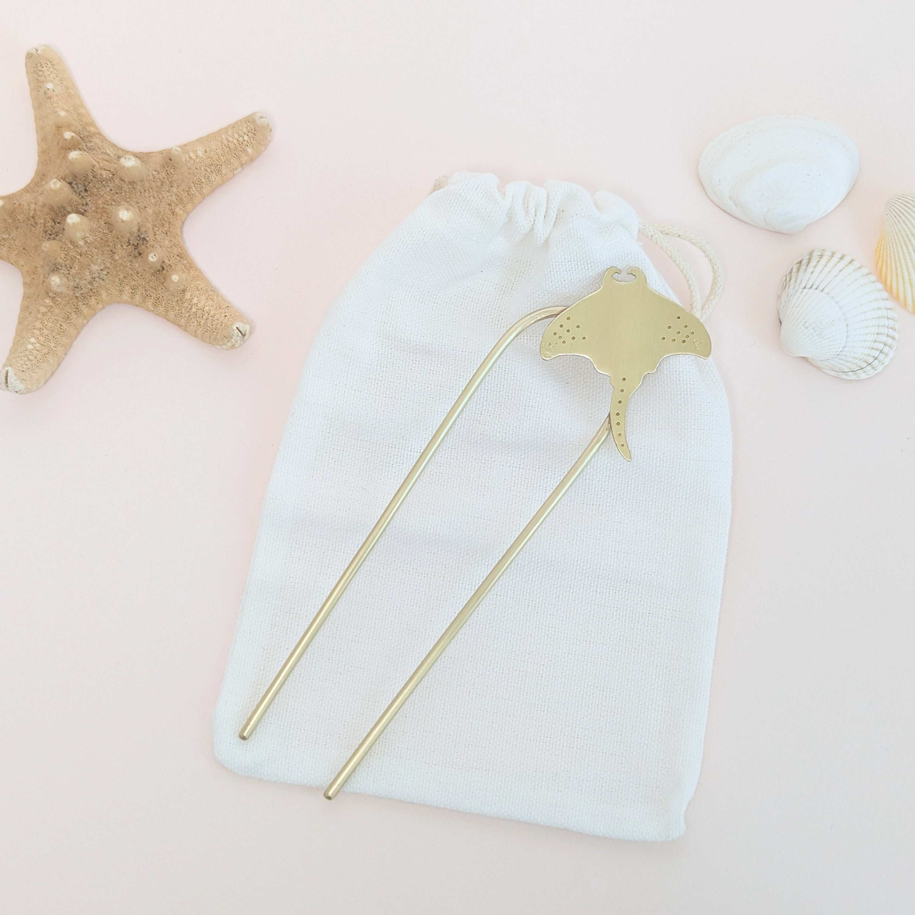 Manta Ray U Pin French hair fork in a brushed brass satin finish - Manta ray secured on the top right of the hair fork with dot and star details on the pectoral finsh laid flat