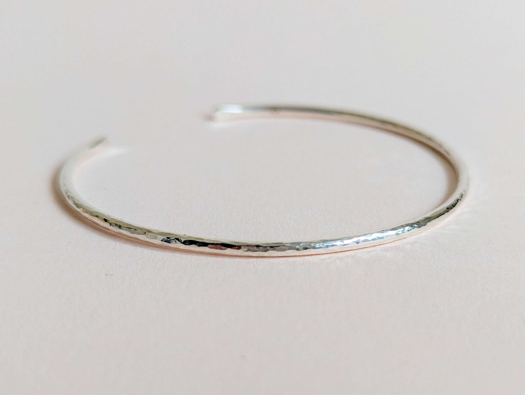 Silver bangle on a light gray background