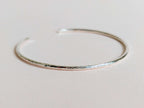 Silver bangle on a light gray background