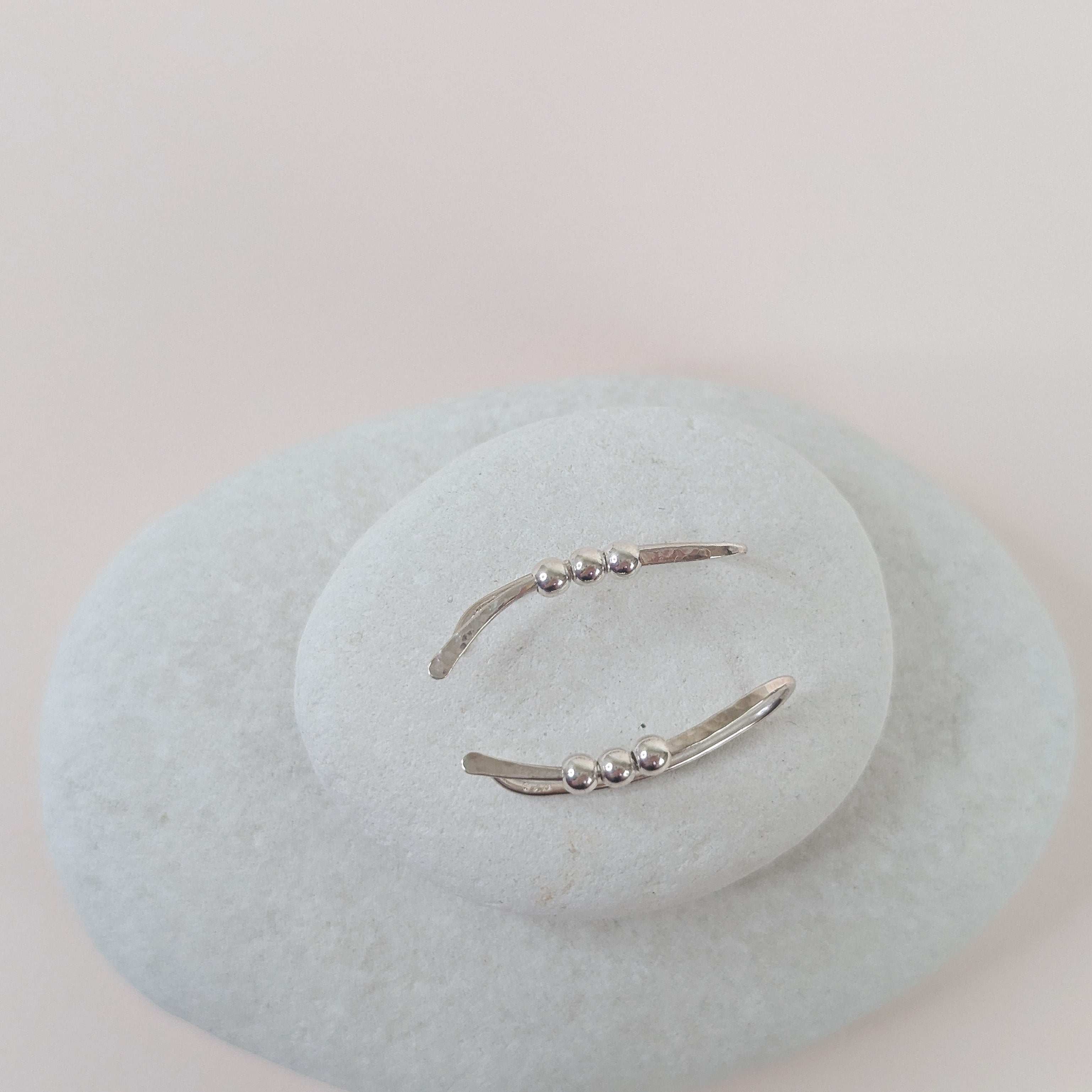 Silver  bead ear climber earrings with small beads on a light white stone