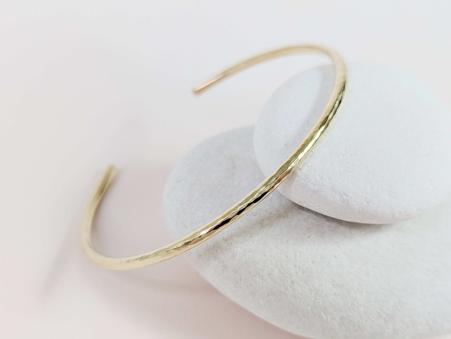 Gold bracelet on a white stone surface