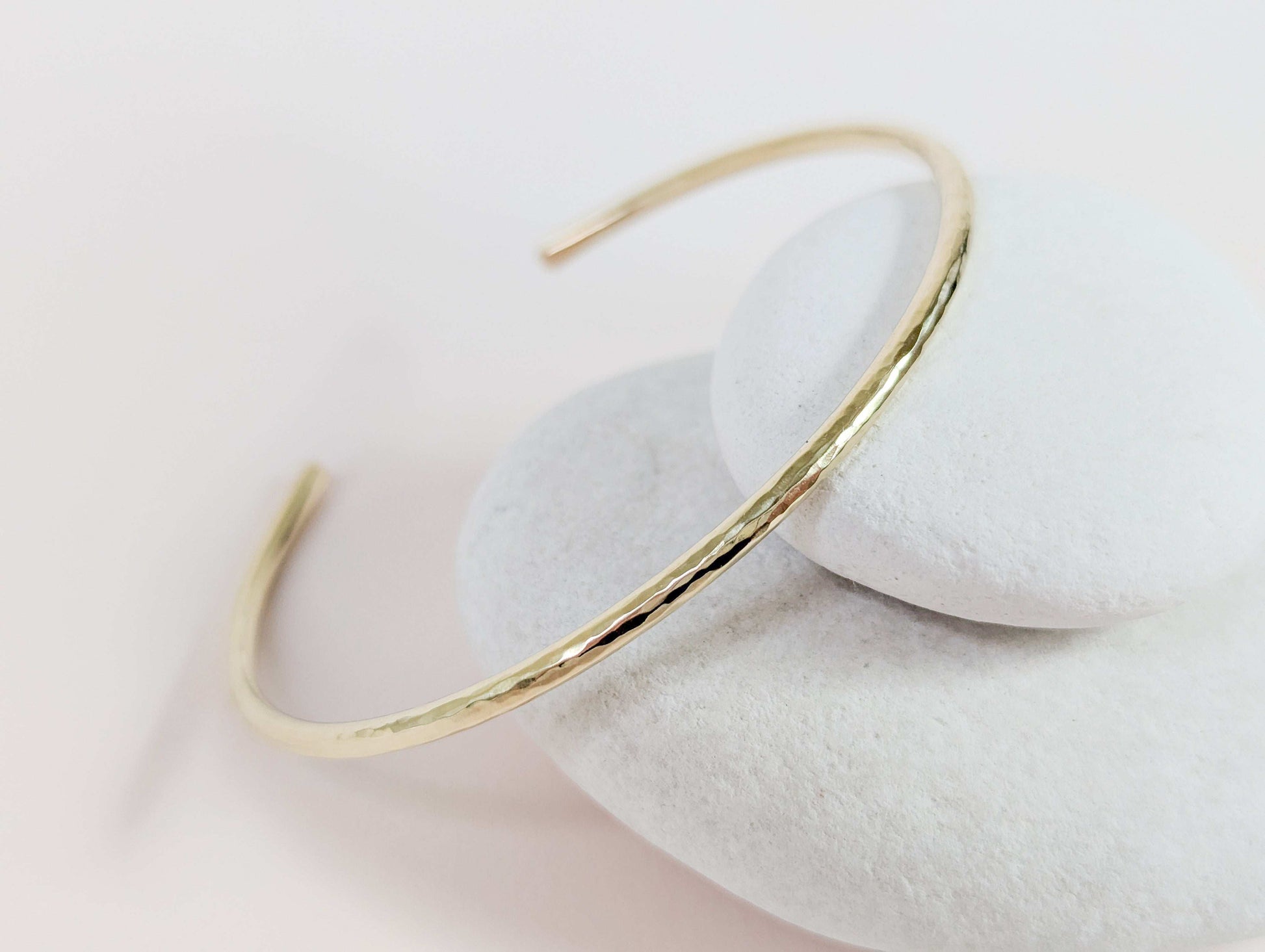 Gold bracelet on a white stone surface