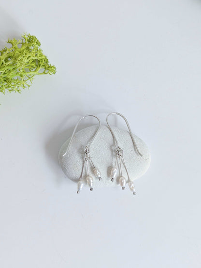 Dainty freshwater seed pearl dangle cascade drop earrings in Sterling silver - laid flat