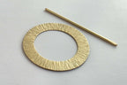 Gold circular metal object on a light gray background