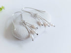 Dainty freshwater seed pearl dangle cascade drop earrings in Sterling silver - side view, close up of seed pearl drops