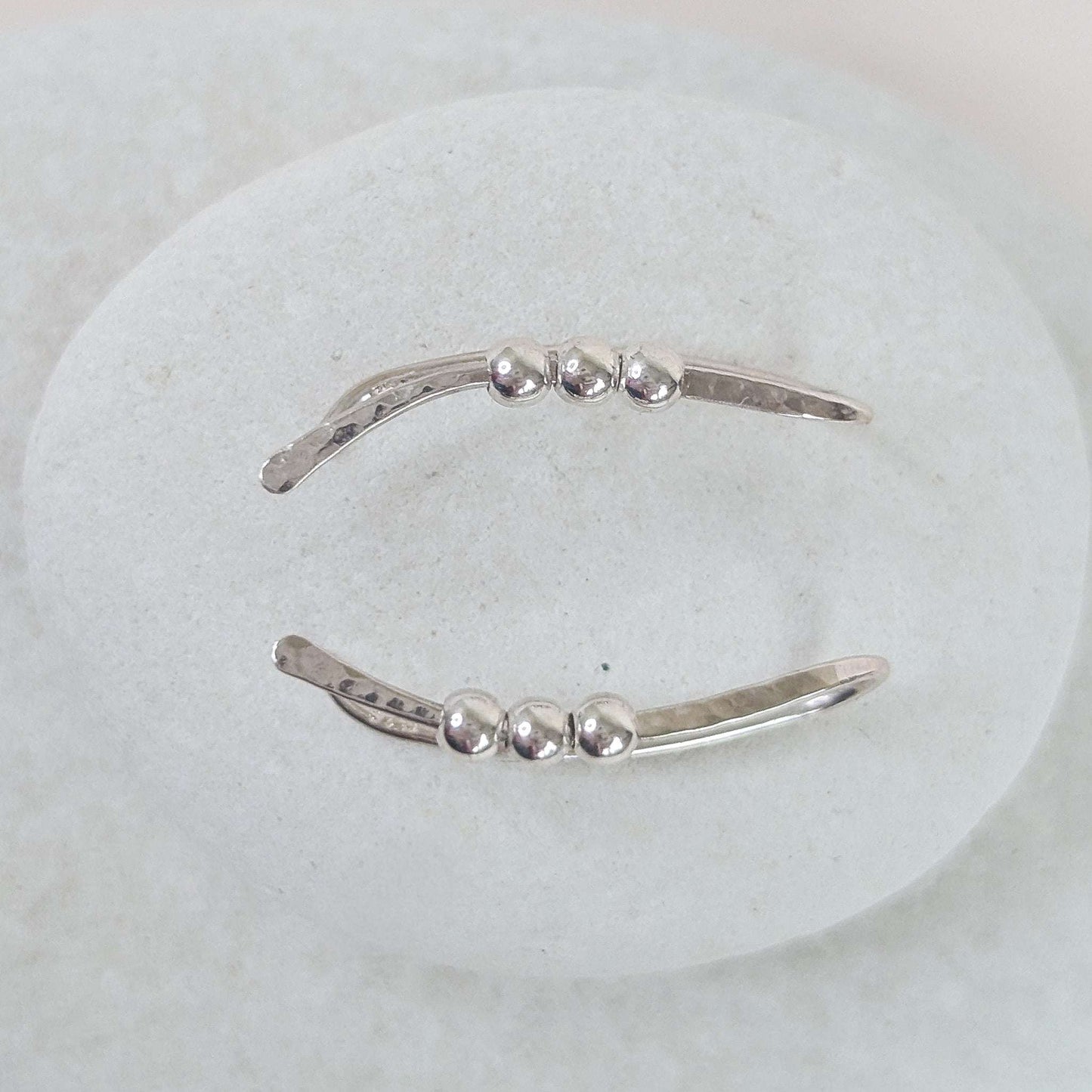 Silver bead ear climber with three small beads on a white background