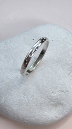 Sterling Silver ring with hand stamped star pattern on a light gray stone surface