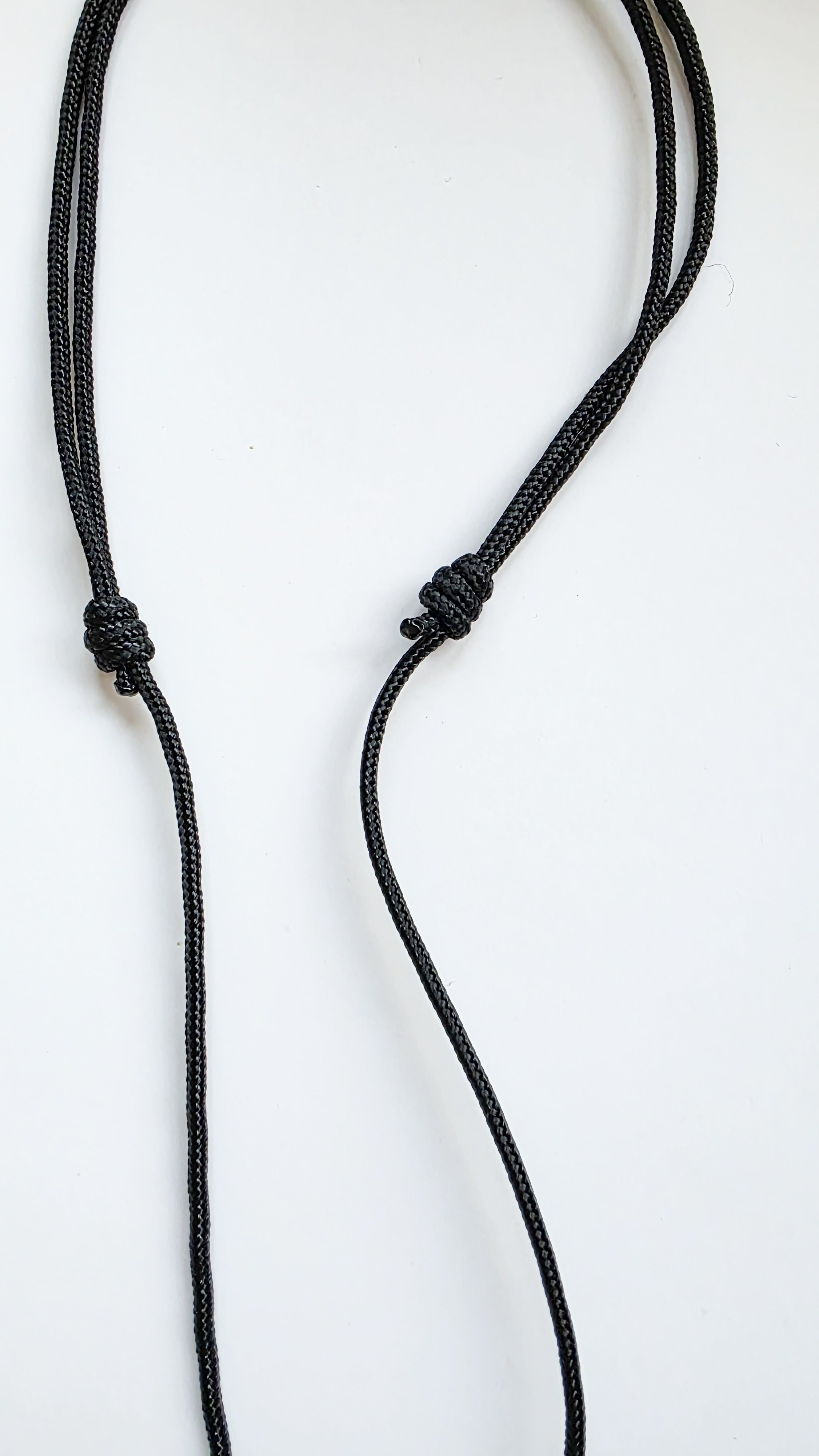 adjustable black cord necklace with a knot on a white background