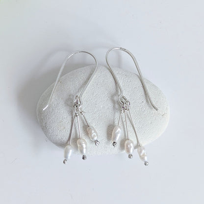 Dainty freshwater seed pearl dangle cascade drop earrings in Sterling silver - laid flat