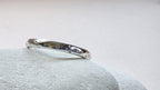 Sterling Silver ring with hand stamped star pattern on a light gray stone surface