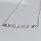 Dainty freshwater seed pearl bar necklace - close up of seed pearl bar containing 5 seed pearls with 2 sterling silver balls on each end