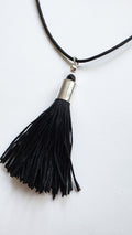 Black tassel necklace with silver accent on a white background