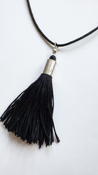 Black tassel necklace with silver accent on a white background