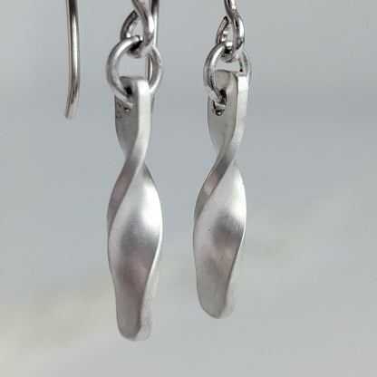 Minimalist satin brushed sterling silver twist drop earrings - macro view